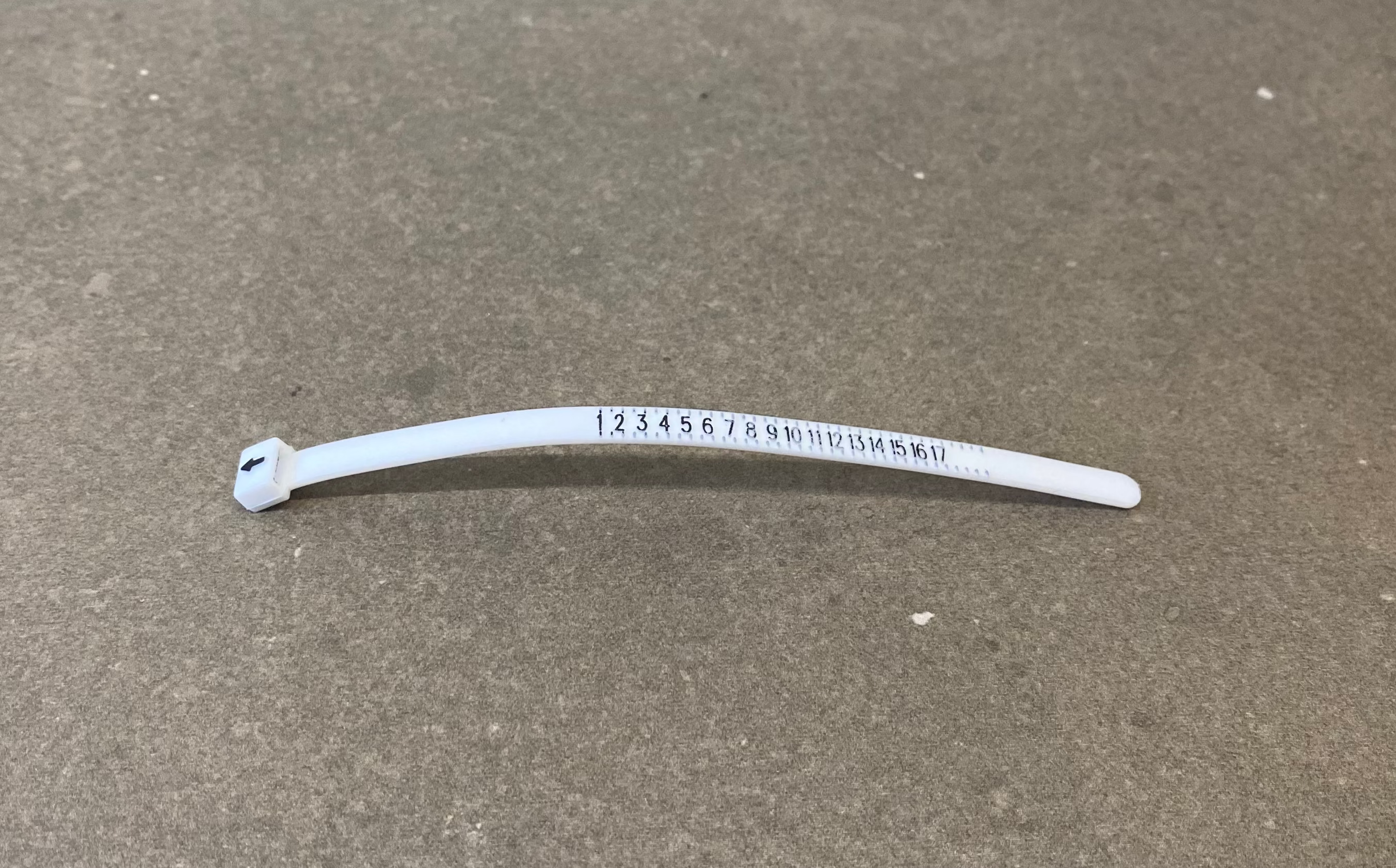 White plastic strap with a label on a gray surface