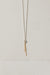 Silver necklace with a 10k gold chain dangling from a textured circle charm by Camillette Jewelry
