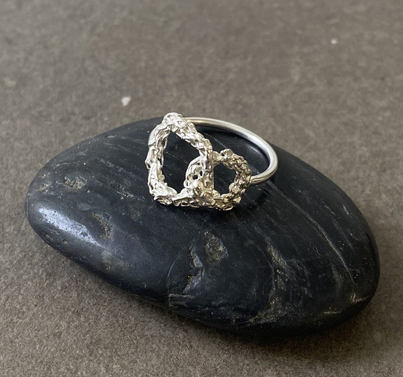 Silver ring on a black stone with a gray background